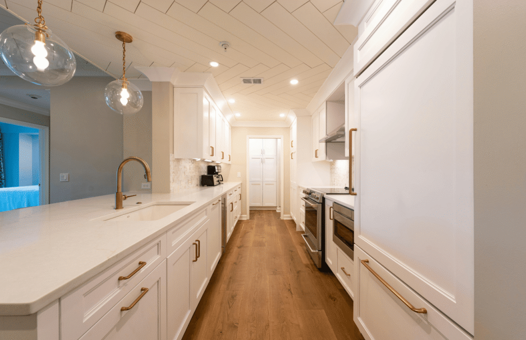 Completed modern home renovation featuring open concept kitchen with new flooring, fresh paint, and updated lighting fixtures.