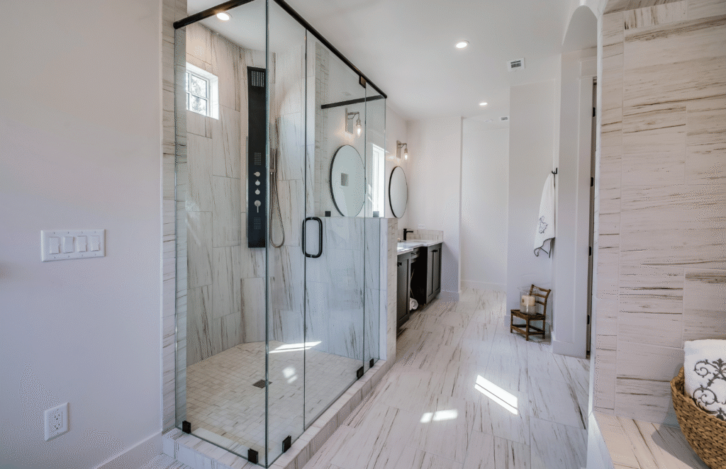 Contemporary walk-in shower with glass enclosure and tiled walls in a modern bathroom renovation.