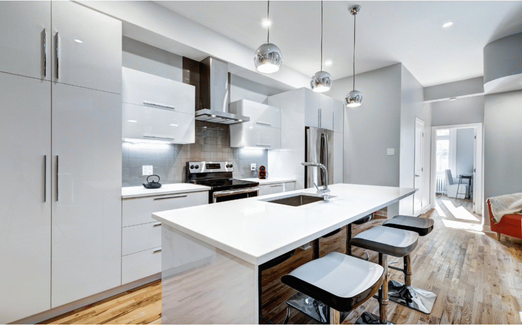 Stylish renovated kitchen with new cabinetry, countertops, modern lighting, and upgraded appliances.